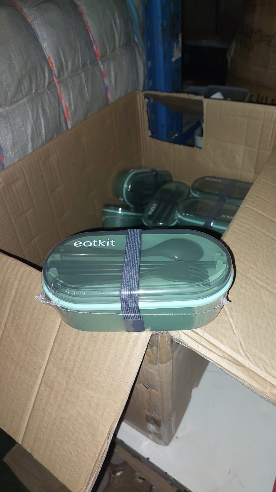 Green food containers with lids on a cardboard surface