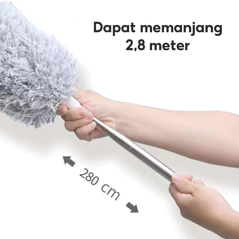 Gambar ini menunjukkan tangan yang memegang gagang kemoceng berwarna perak yang dapat dipanjangkan (teleskopik). Kepala kemoceng microfiber berwarna abu-abu terlihat di ujung gagang. Ada panah hitam yang menunjuk ke kiri dan ke kanan dengan tulisan "280 cm" di antara panah tersebut, menunjukkan panjang maksimal gagang. Di bagian atas gambar, terdapat teks besar berwarna hitam yang bertuliskan "Dapat memanjang 2,8 meter". Ini mengindikasikan fitur kemoceng yang bisa diperpanjang hingga 2,8 meter atau 280 cm.