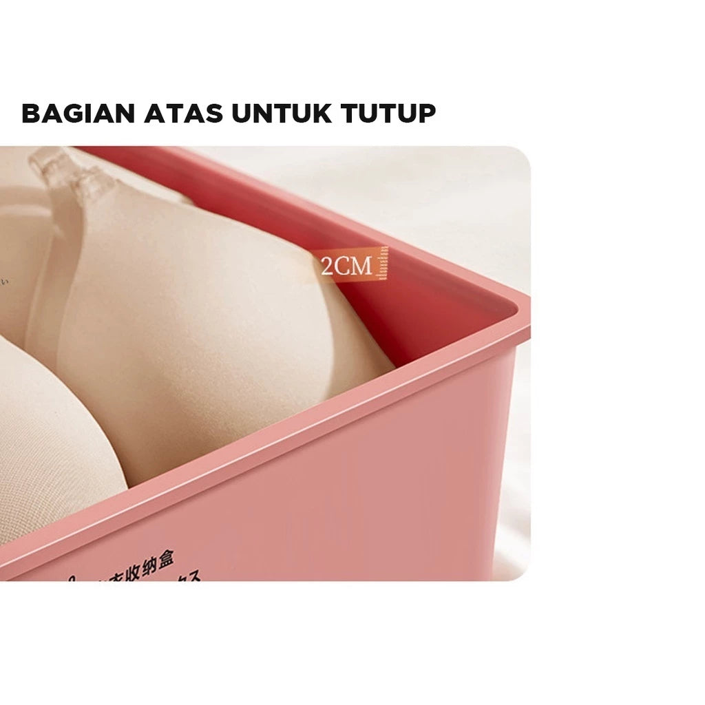 Penampakan sisi atas kotak penyimpanan berwarna merah muda pastel, menunjukkan bagian tepi wadah setinggi 2cm, ideal untuk menyimpan bra berwarna krem yang terlihat rapi di dalamnya. Terdapat teks 'BAGIAN ATAS UNTUK TUTUP' berwarna putih di latar belakang hitam, mengindikasikan bahwa wadah ini dilengkapi tutup."