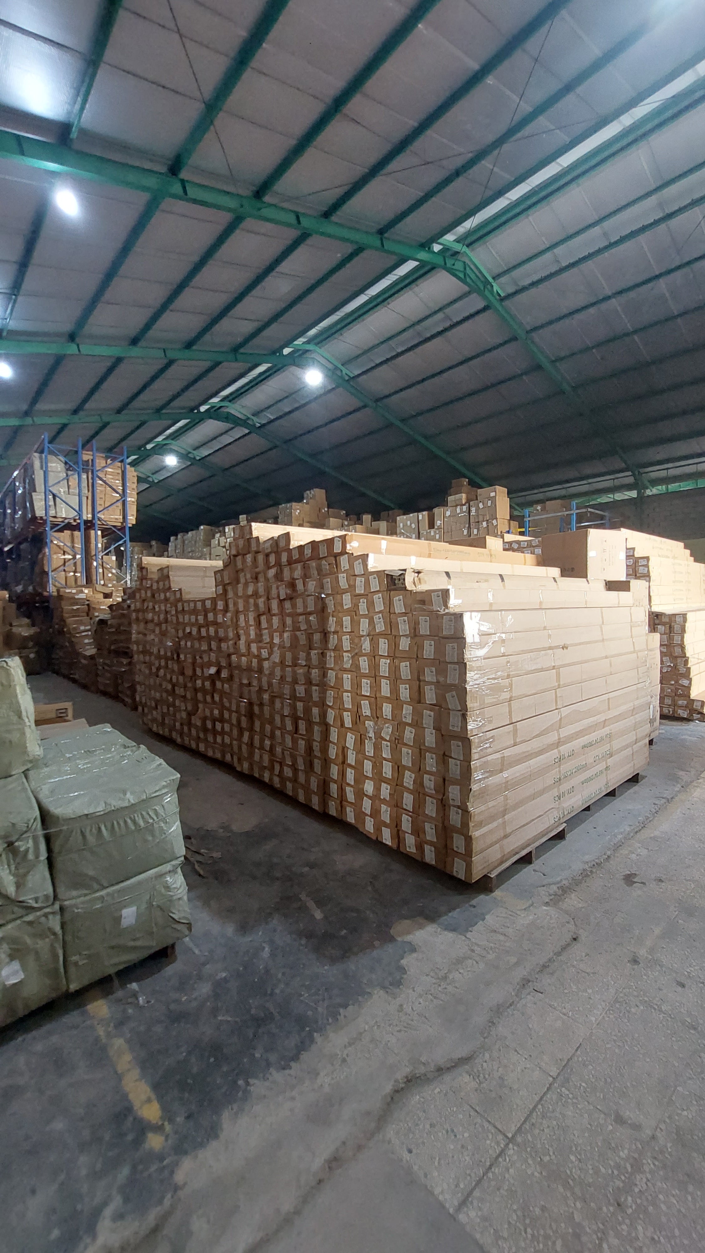 Stacks of wooden pallets inside a warehouse.