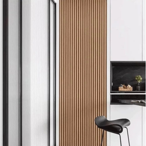 Panel dinding WPC Hoptech motif kayu vertikal cokelat di interior modern, menampilkan desain minimalis di samping pintu kaca dan lemari putih.
