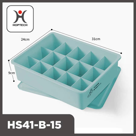 "Tampilan tiga perempat dari organizer laci Hoptech HS41-B-15 berwarna biru kehijauan pastel dengan 15 kompartemen terpisah dan penutupnya di bawah. Dimensi produk terlihat jelas: panjang 31cm, lebar 24cm, dan tinggi 9cm. Logo Hoptech berwarna merah dan hitam tertera di pojok kiri atas gambar. Ikon kaus kaki dan celana dalam terlihat di sisi kotak, menunjukkan fungsinya untuk penyimpanan pakaian dalam atau kaus kaki."
