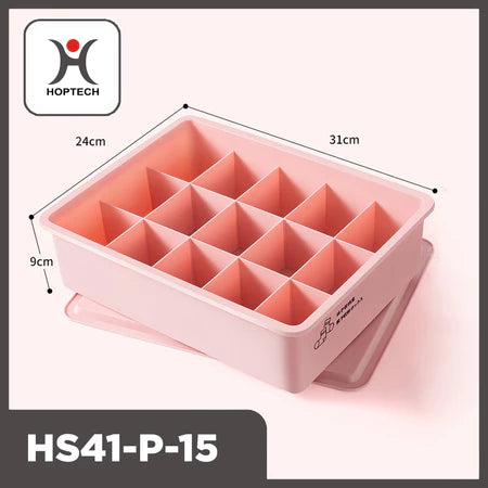 Tampilan tiga perempat dari organizer laci Hoptech HS41-P-15 berwarna merah muda pastel dengan 15 kompartemen terpisah dan penutupnya di bawah. Dimensi produk terlihat jelas: panjang 31cm, lebar 24cm, dan tinggi 9cm. Logo Hoptech berwarna merah dan hitam tertera di pojok kiri atas gambar. Ikon kaus kaki dan celana dalam terlihat di sisi kotak, menunjukkan fungsinya untuk penyimpanan pakaian dalam atau kaus kaki."