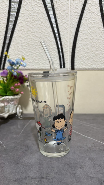 Clear tumbler with cartoon characters and text on a gray surface