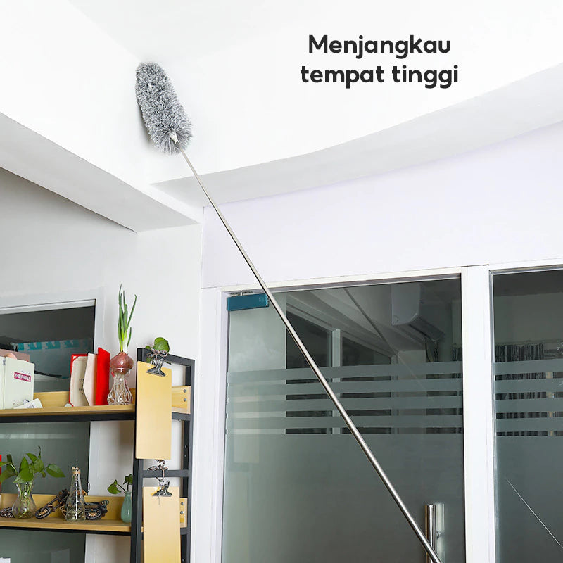 
The image shows an extendable duster with a grey fluffy head cleaning a high corner of a white ceiling. The text "Menjangkau tempat tinggi" (Reaches high places) highlights its function.