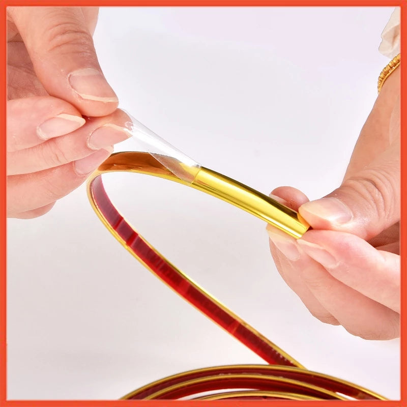 A person holding a red and gold colored wall sticker decor strip, with visible adhesive on the edges.