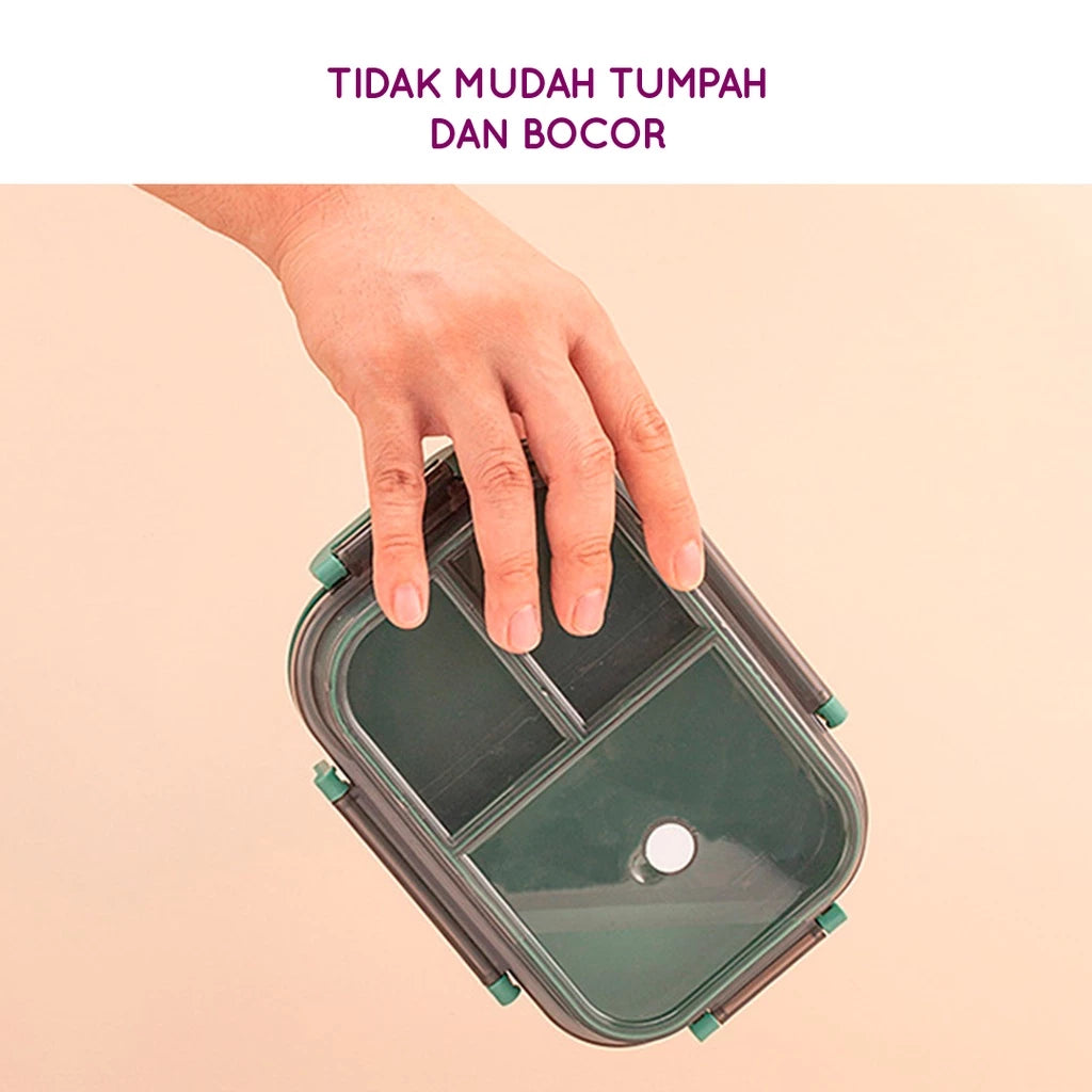 Sebuah tangan memegang kotak makan siang satu tingkat berwarna hijau tua dengan tutup transparan yang dilengkapi sekat internal dan klip pengunci berwarna hijau muda, menunjukkan bahwa kotak tidak mudah tumpah atau bocor.
